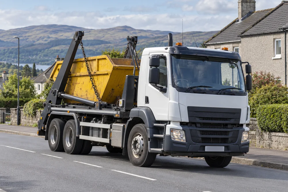 A skip delivery vehicle on a residential street